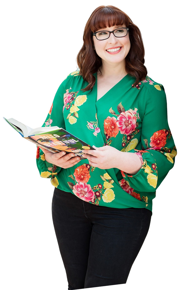 Cut-out image of Emily Pike Stewart holding an open book, smiling, and looking to the right. She's wearing a green shirt and glasses.